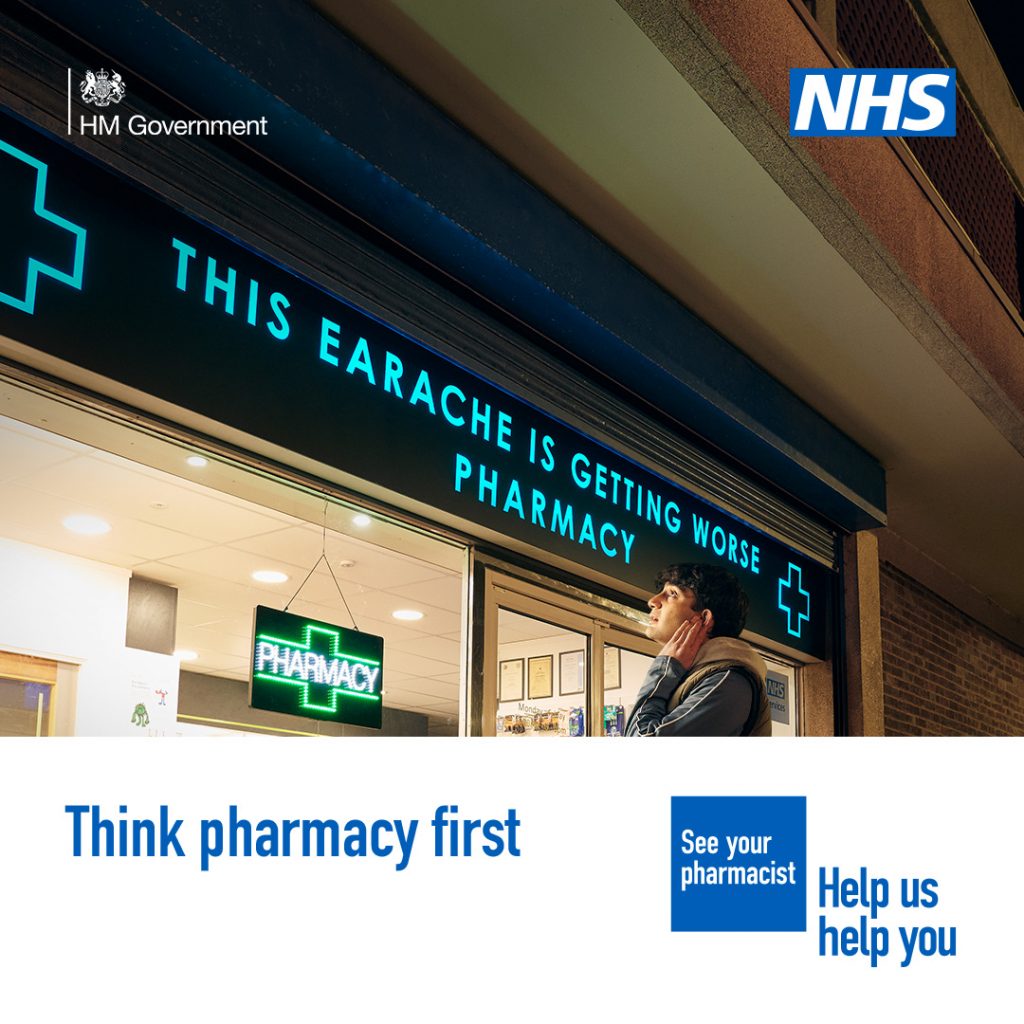 A person is standing outside a pharmacy holding the side of their face in discomfort. The sign above the pharmacy reads 'This earache is getting worse pharmacy' A lower third box features in the bottom on the image. Text in the box reads: 'Think pharmacy first'